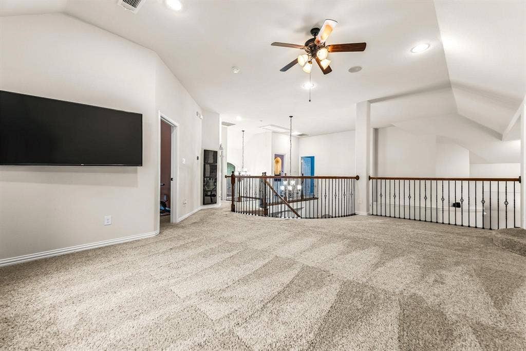 12467 Fallcreek Drive, Frisco, TX 75035 Expansive carpeted loft with vaulted ceiling, recessed lighting, and a ceiling fan