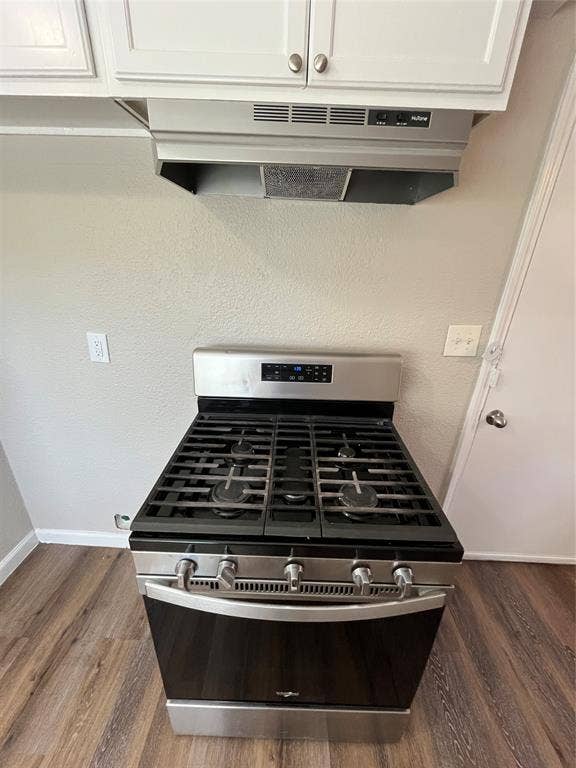 14206 Osage Drive, Balch Springs, TX 75180 Stainless steel gas range with a black cooktop, under-cabinet range hood, white upper cabinetry, and wood-finish flooring