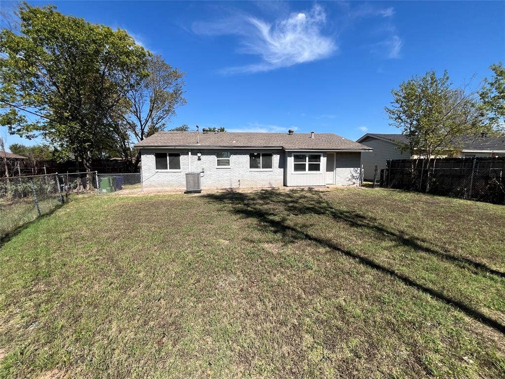 14206 Osage Drive, Balch Springs, TX 75180 Expansive backyard featuring a chain link fence, a wood privacy fence, and mature trees