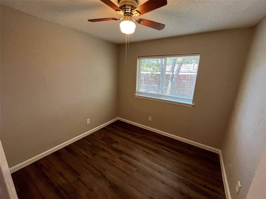 14206 Osage Drive, Balch Springs, TX 75180 Wood-finish flooring, neutral wall tones, ceiling fan with integrated lighting, and a large window with blinds