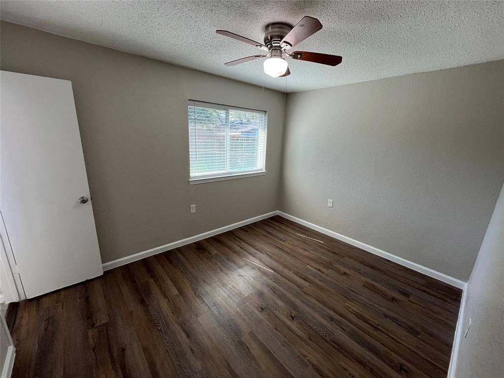 14206 Osage Drive, Balch Springs, TX 75180 Wood-finish flooring with neutral wall tones and a ceiling fan with integrated lighting