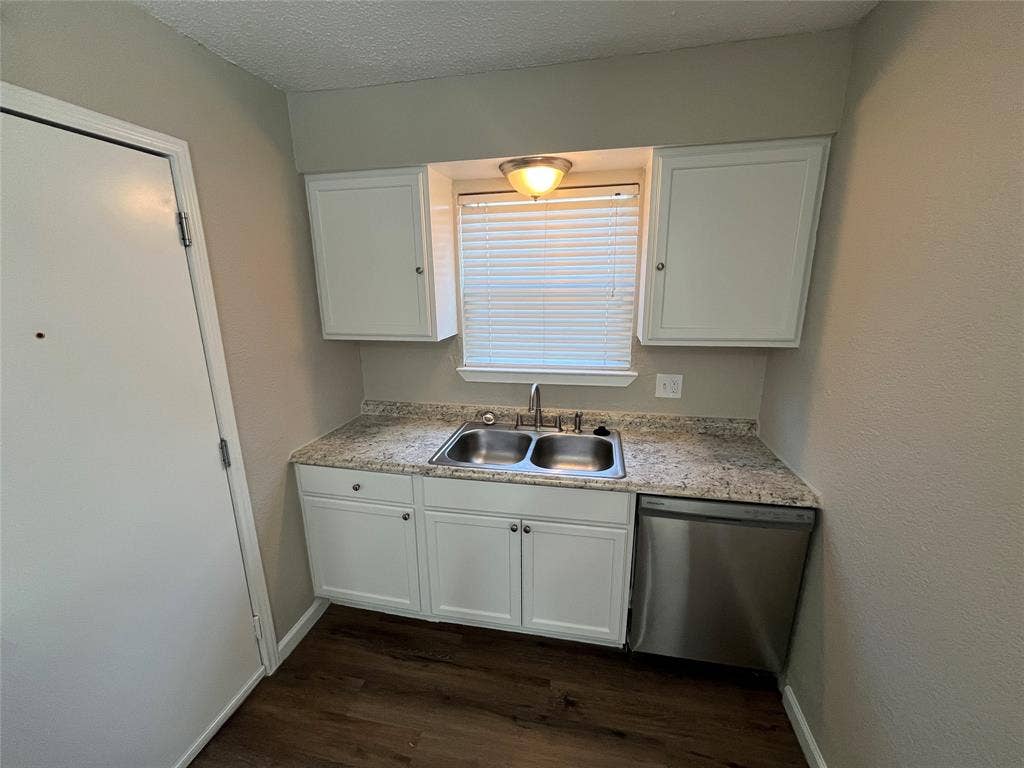 14206 Osage Drive, Balch Springs, TX 75180 Dual stainless steel sink with a chrome faucet, white cabinetry, granite-finish countertop, and stainless steel dishwasher