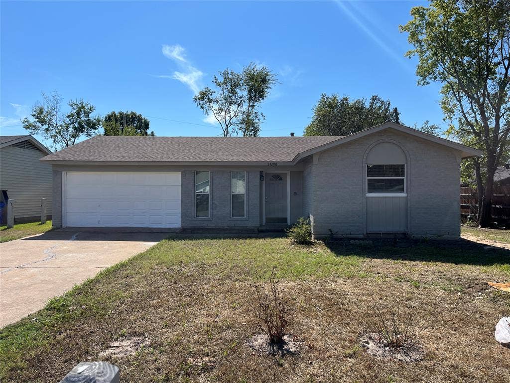 14206 Osage Drive, Balch Springs, TX 75180 Single-story residence featuring a two-car garage, an arched window detail, and a concrete driveway