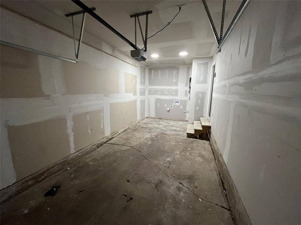 9527 Musgrave Drive, Dallas, TX 75217 Garage space featuring concrete flooring, unpainted drywall, recessed lighting, and integrated laundry hookups