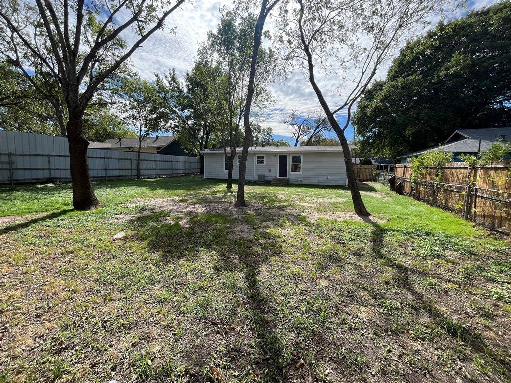 9527 Musgrave Drive, Dallas, TX 75217 Backyard featuring horizontal siding exterior, perimeter wood and metal fencing, and mature trees