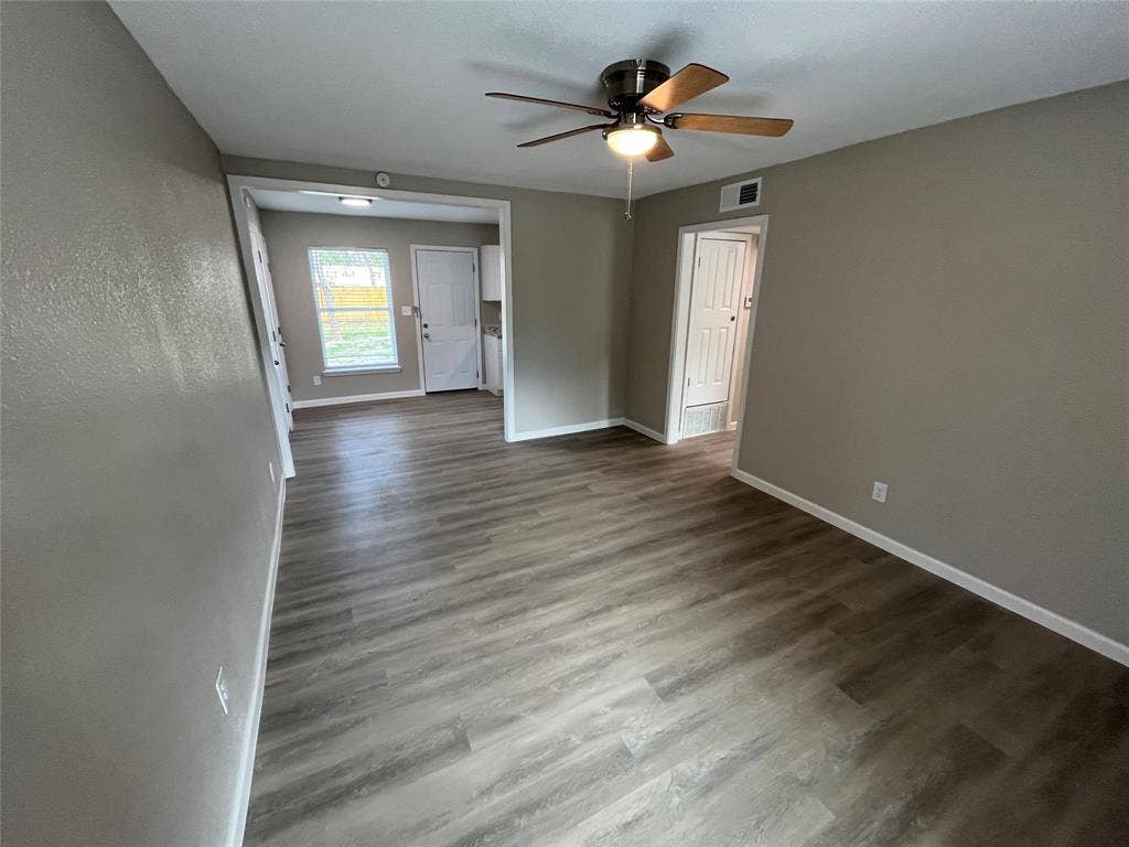 9527 Musgrave Drive, Dallas, TX 75217 Wood-finish flooring, neutral wall color, ceiling fan with integrated lighting, and multi-panel interior doors