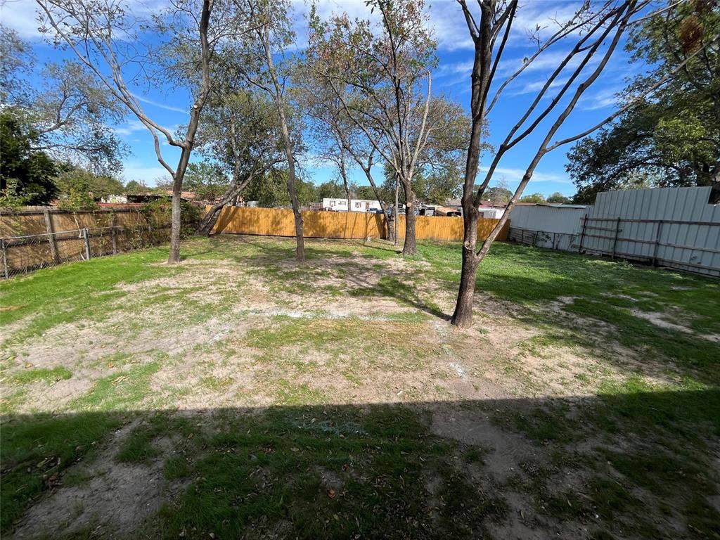 9527 Musgrave Drive, Dallas, TX 75217 Backyard featuring mature trees and wood-style perimeter fencing