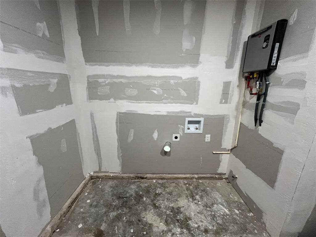 9527 Musgrave Drive, Dallas, TX 75217 Utility area featuring unfinished drywall, a tankless water heater, and integrated plumbing hookups