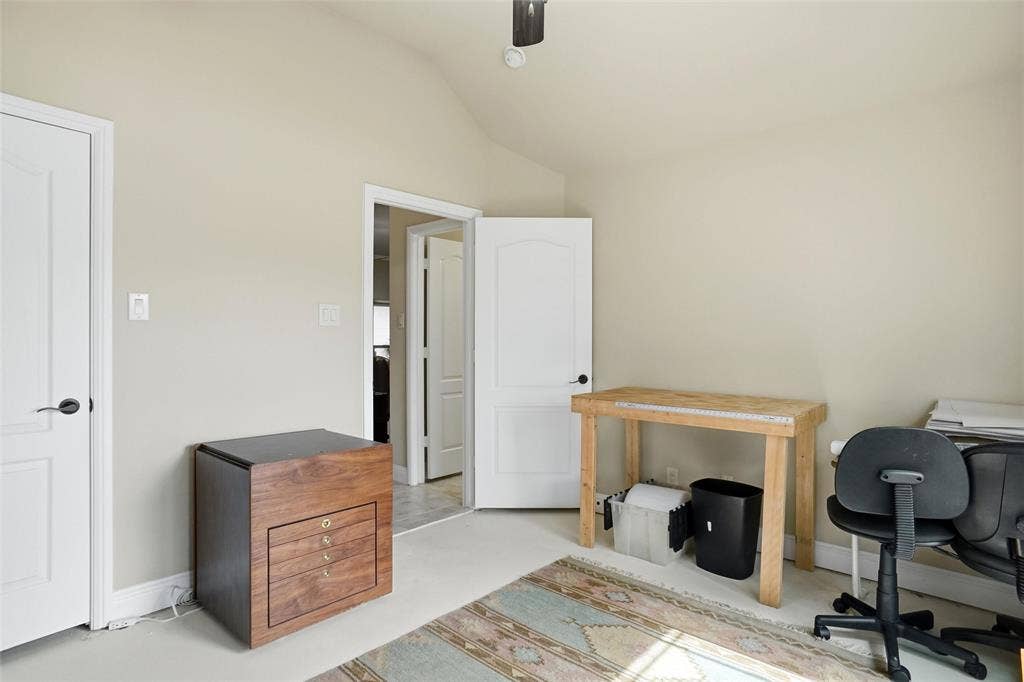 Vaulted ceiling, neutral wall tones, and arched-panel interior doors with matte black hardware