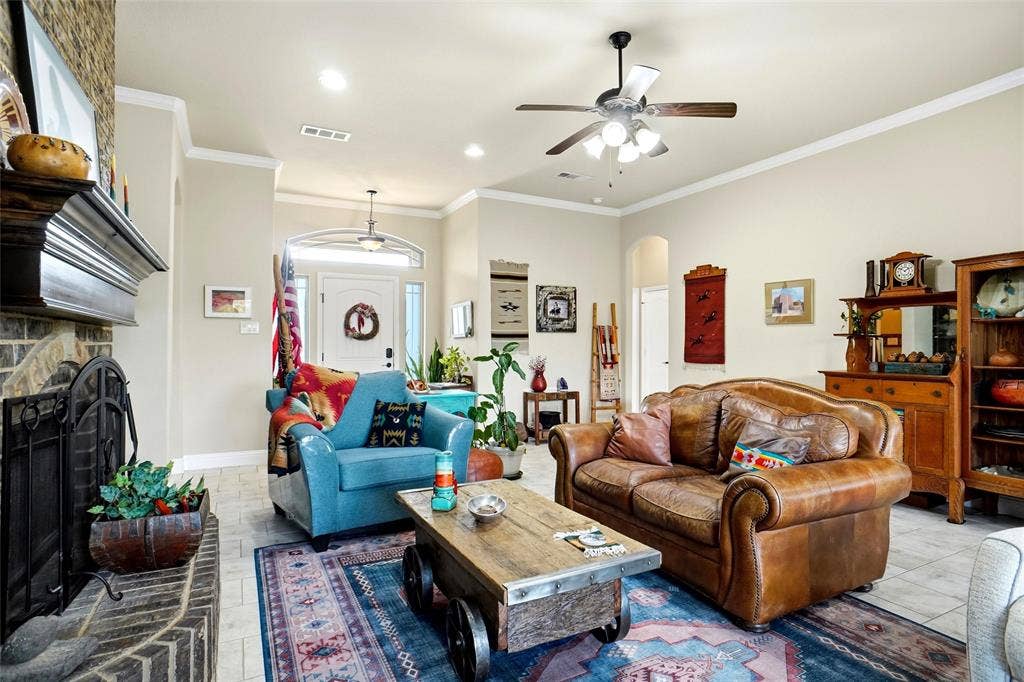 Living room featuring a floor-to-ceiling brick fireplace with a custom mantel, recessed lighting, tile flooring, and a multi-blade ceiling fan
