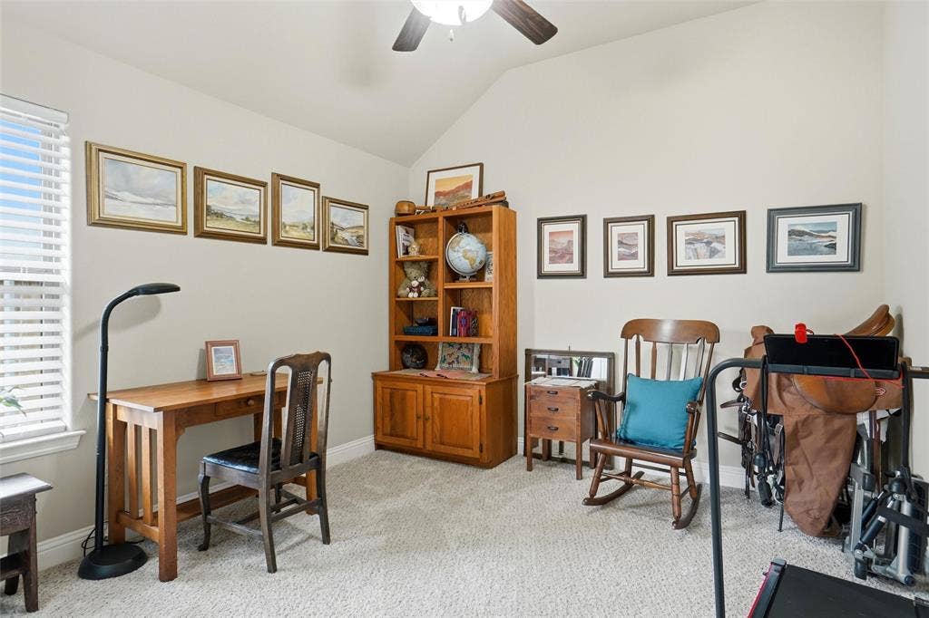 Vaulted ceilings featuring a central ceiling fan and neutral wall color palette