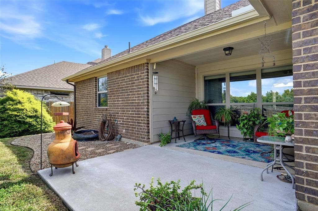 Covered concrete patio featuring a brick and horizontal siding exterior, overhead recessed lighting, and a gravel landscape border