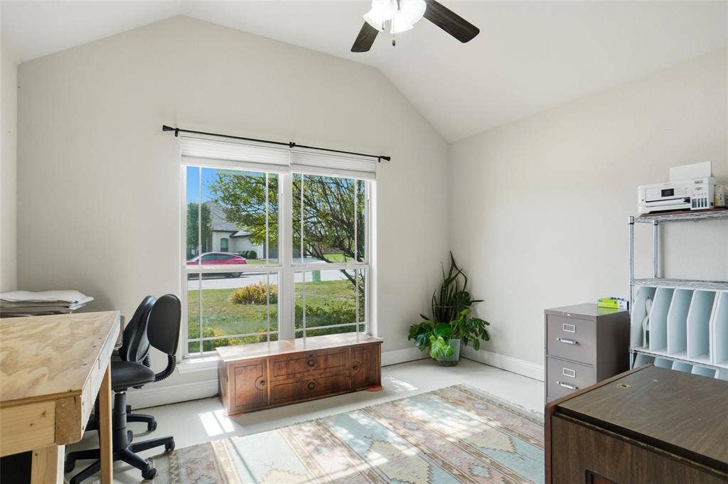 Vaulted ceilings, expansive double-pane windows, and a multi-blade ceiling fan