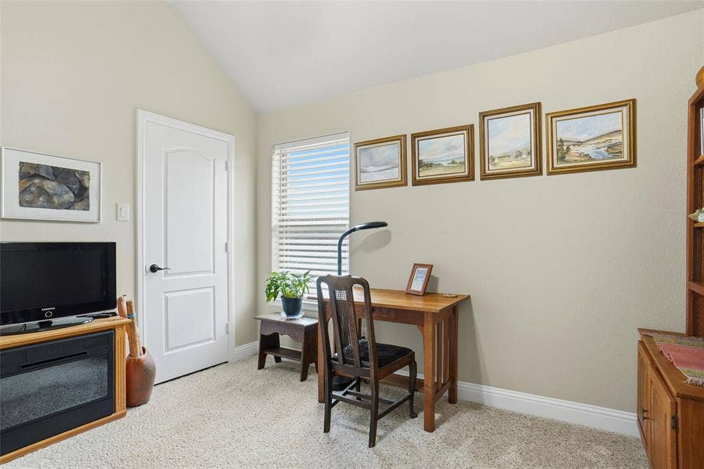 Room with vaulted ceiling, neutral wall tones, wall-to-wall carpeting, and a single-pane window with horizontal blinds