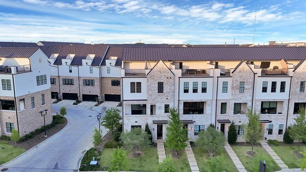 Modern townhome exteriors featuring light-colored brick and white siding