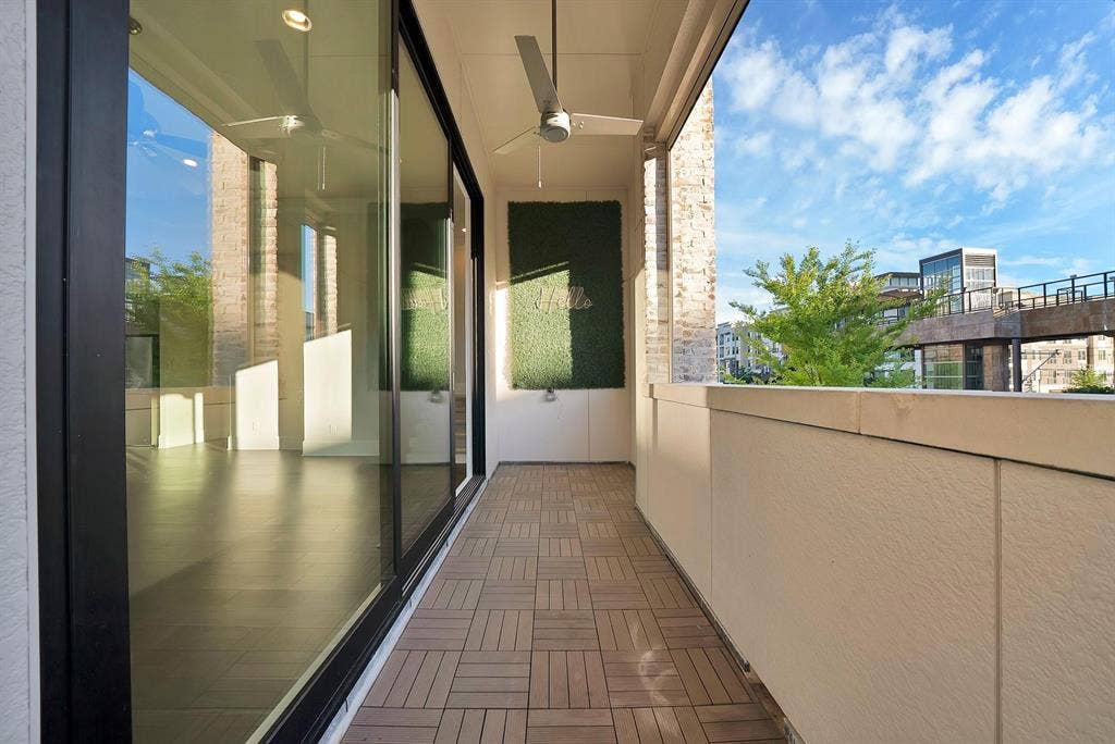 Balcony featuring wood-finish tile flooring, ceiling fan, and sliding glass doors