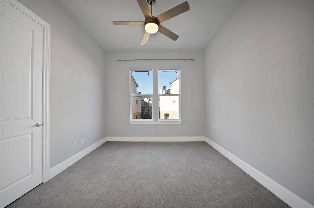 Recessed window with white trim, a flush-mount ceiling fan with integrated lighting, and neutral-toned wall-to-wall carpeting