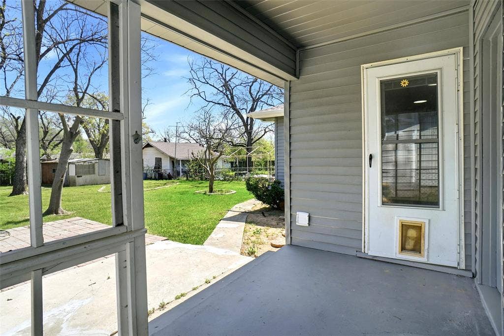 705 Vine Street, Euless, TX 76040 covered rear porch with storm door into kitchen and pavestone patio deck extension