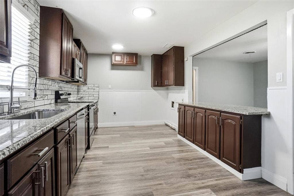 705 Vine Street, Euless, TX 76040 stainless farm sink, subway backsplash, fridge can be placed at end of kitchen or in corner opposite the cooking area and upper cabinets removed