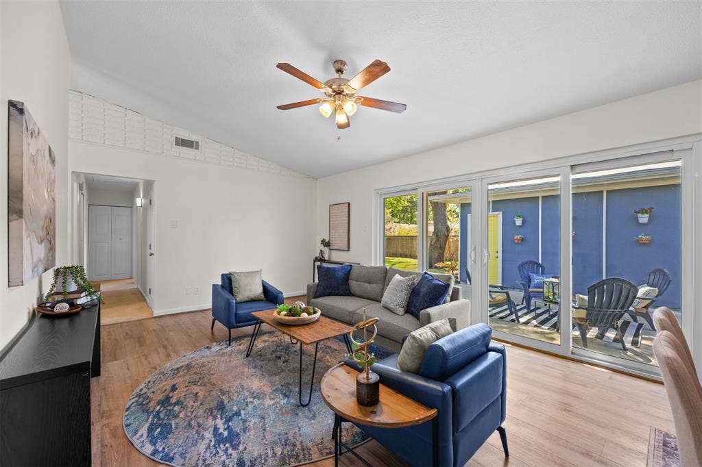 1118 Pacific Drive, Richardson, TX 75081 Vaulted ceiling with an overhead fan, wood-finish flooring, and sliding glass patio doors