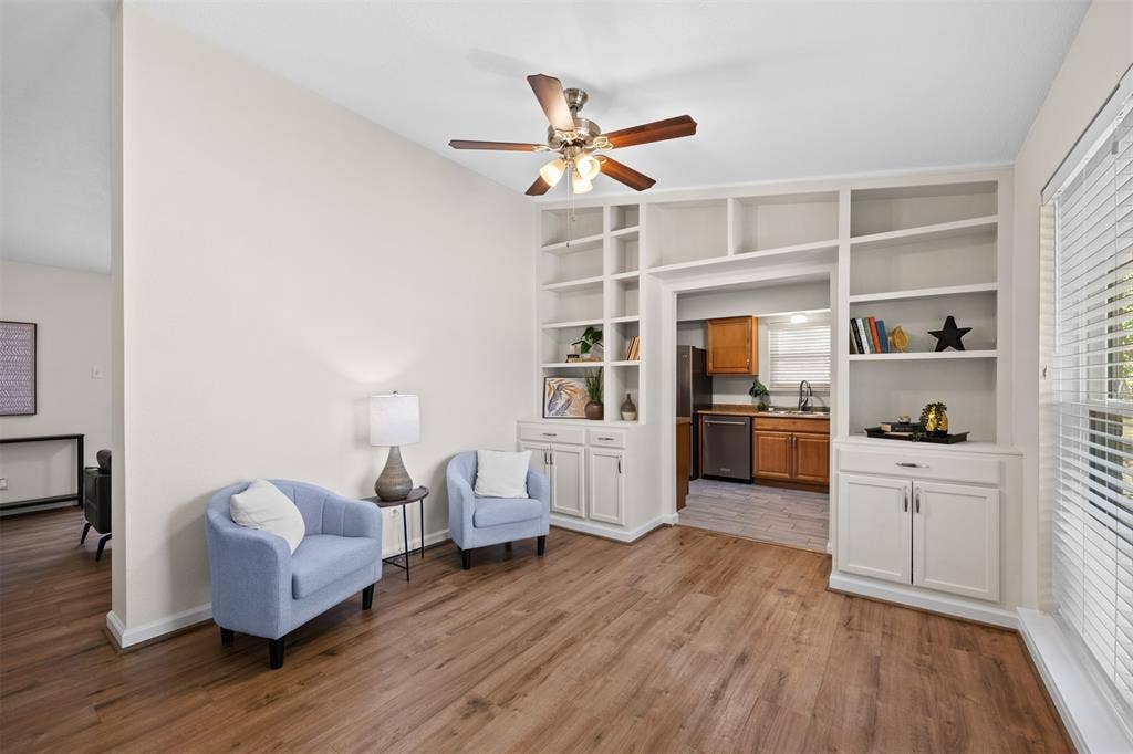 1118 Pacific Drive, Richardson, TX 75081 Wood-finish flooring, built-in shelving, ceiling fan with light fixture, and window with blinds