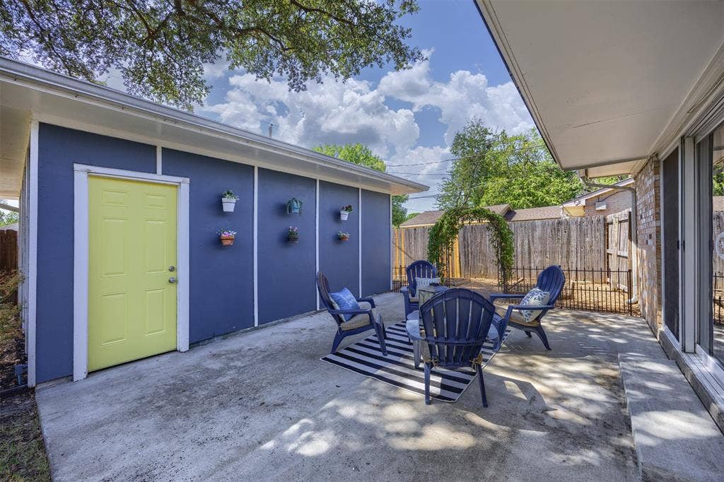 1118 Pacific Drive, Richardson, TX 75081 Concrete patio with an overhead awning and a vibrant yellow exterior door