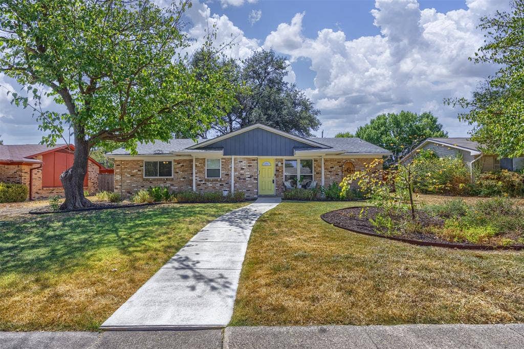 1118 Pacific Drive, Richardson, TX 75081 Brick exterior with blue siding accents, covered front porch, and a vibrant yellow entry door
