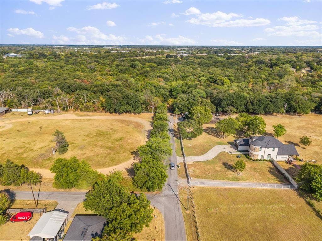 19 No Name Street, Dallas, TX 75217 Expansive property featuring a large residence with a circular drive, surrounded by mature trees and open fields, bordered by a white fence