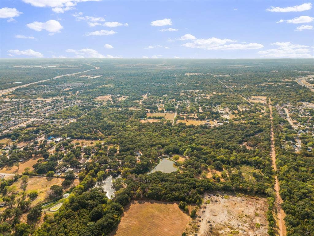 19 No Name Street, Dallas, TX 75217 Expansive aerial landscape featuring a prominent pond, mature tree coverage, and surrounding residential areas