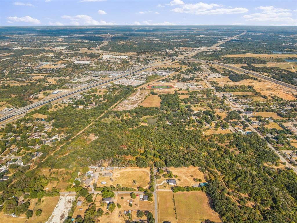 19 No Name Street, Dallas, TX 75217 Expansive aerial perspective featuring a diverse landscape with residential areas, wooded parcels, and transportation infrastructure