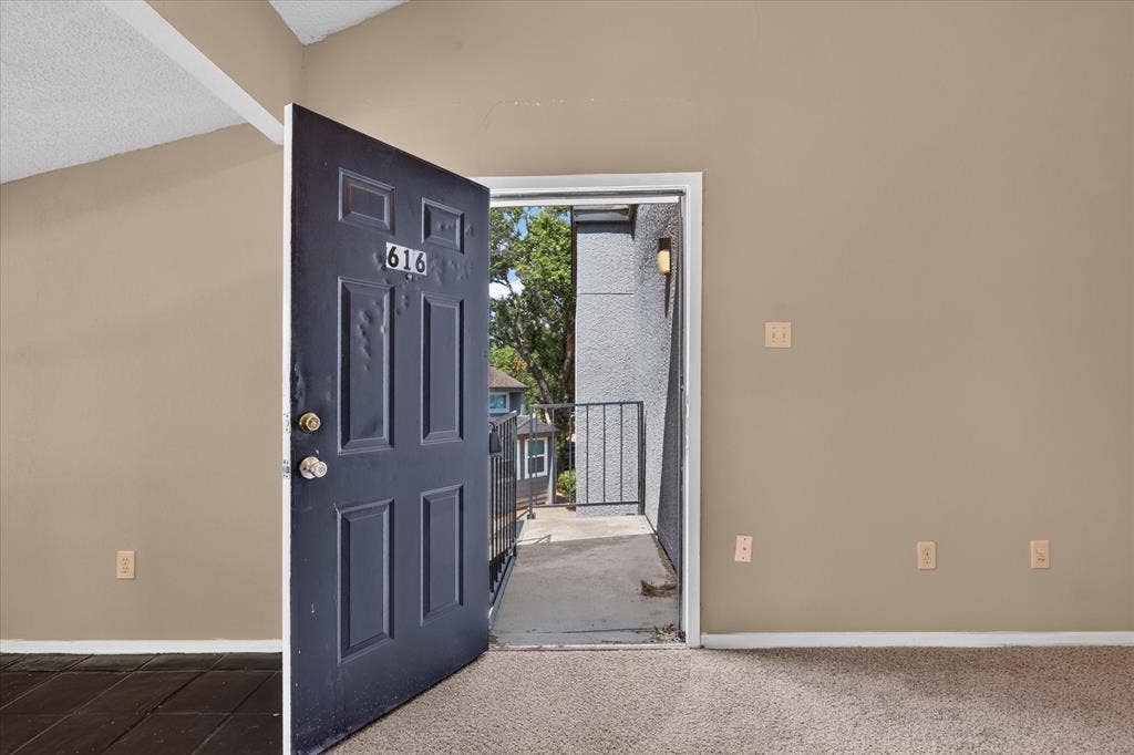 Entry door with paneled design opening to an exterior balcony