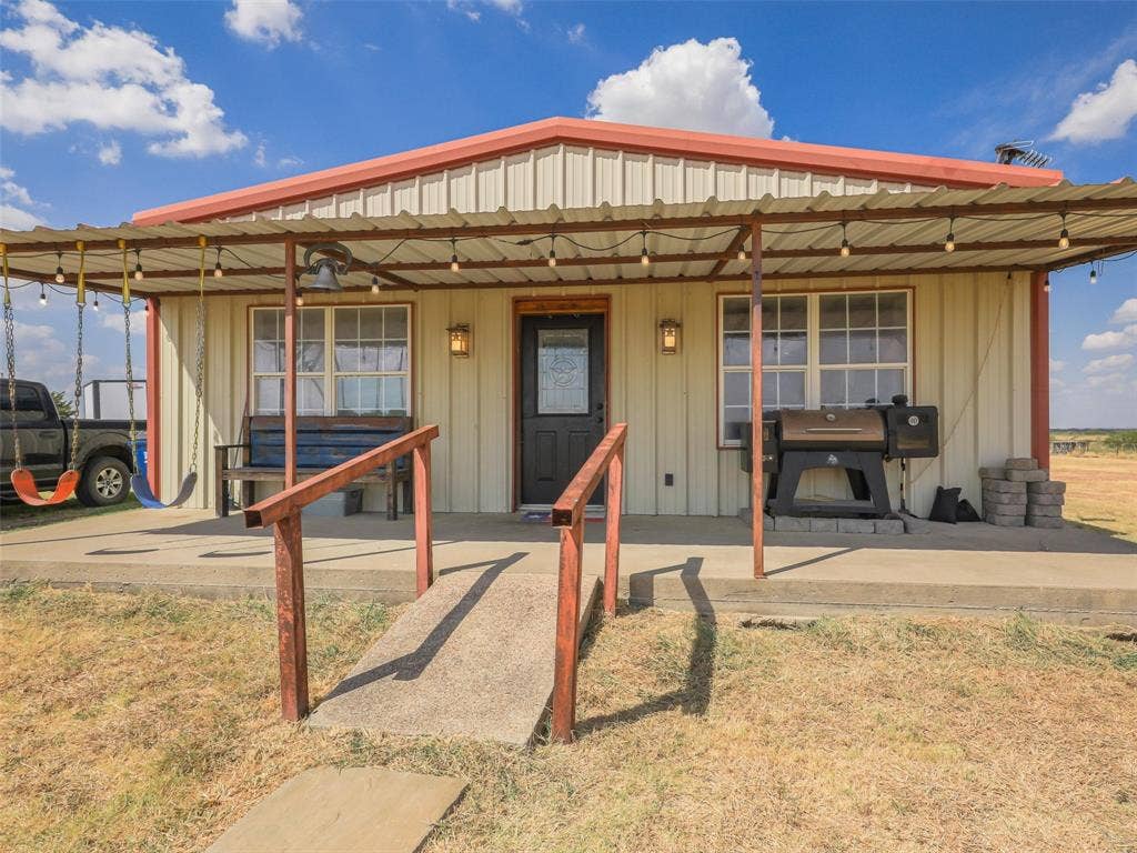 16880 W Fm 455, Celina, TX 75009 Corrugated metal siding with a red metal roof and front porch