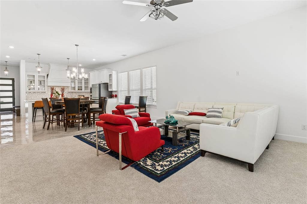 Open-concept living space with light-toned carpeting and tile flooring