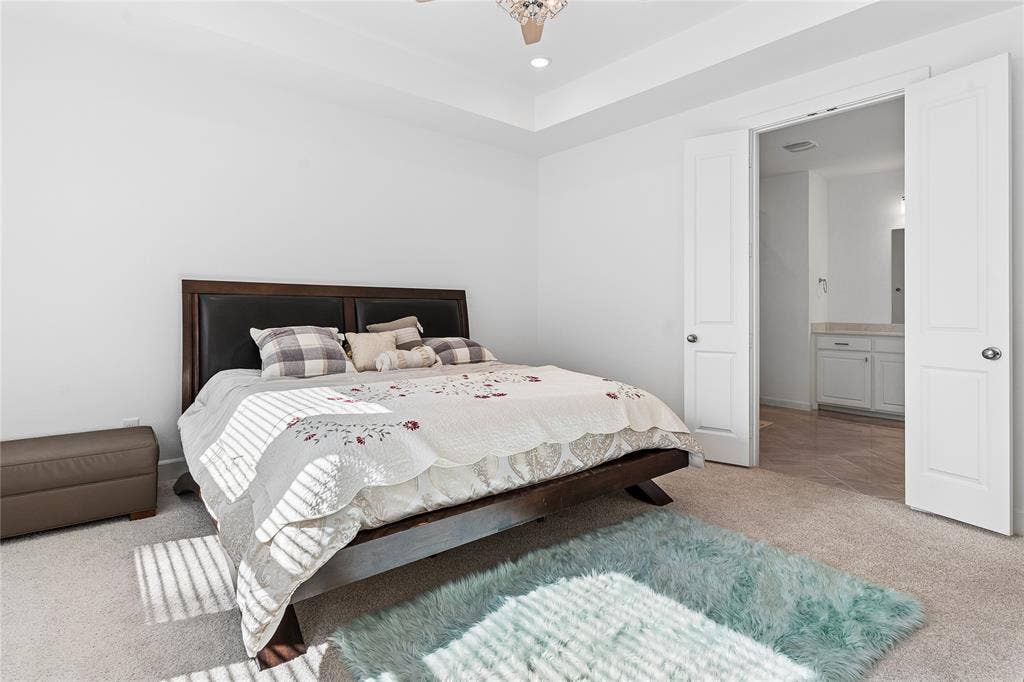 Recessed lighting, tray ceiling, and light-colored carpet flooring