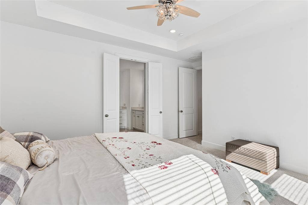 Tray ceiling with recessed lighting and a decorative ceiling fan
