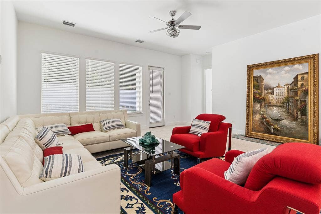 Recessed lighting, ceiling fan with light fixture, multiple windows with blinds, and a glass-top coffee table