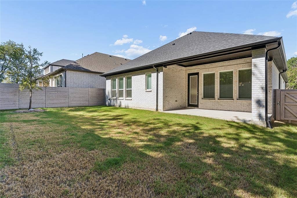 Expansive backyard featuring a privacy fence and a covered concrete patio