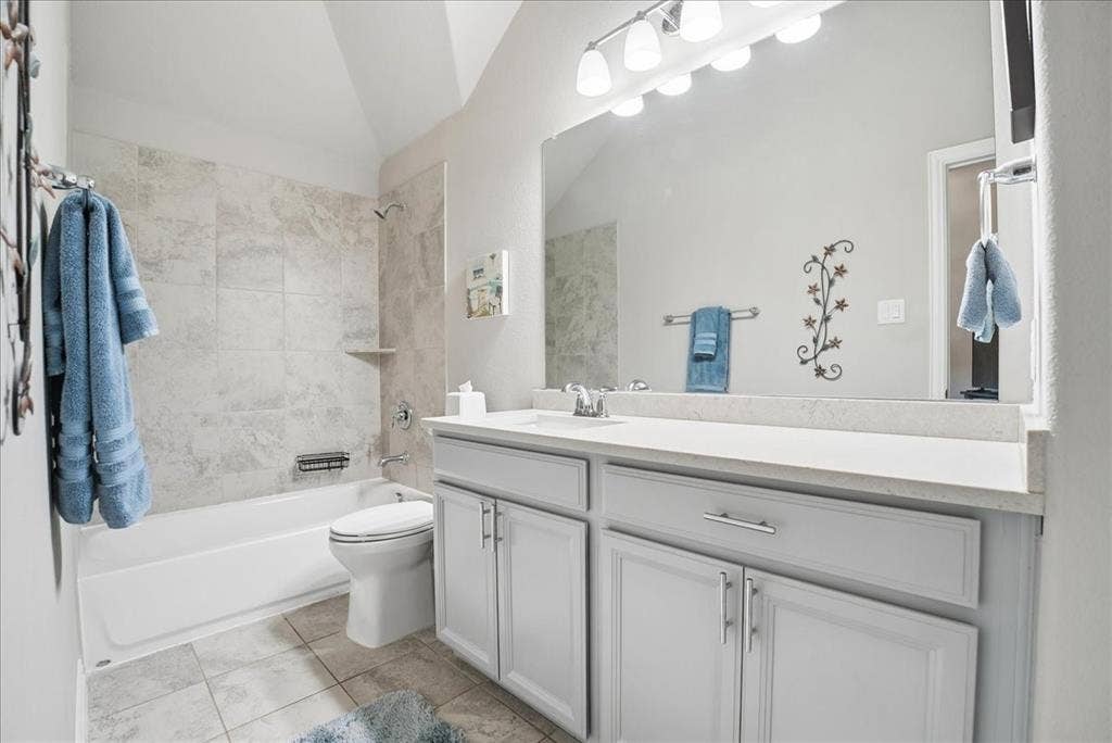 2206 Wellington Lane, Corinth, TX 76210 Private en-suite bath featuring spacious vanity and tiled tub/shower combination.