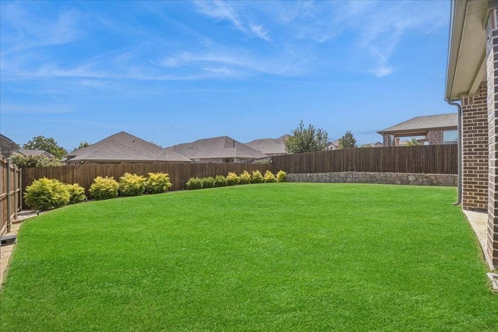 2206 Wellington Lane, Corinth, TX 76210 Spacious, beautifully maintained backyard with lush lawn and plenty of room for outdoor enjoyment.