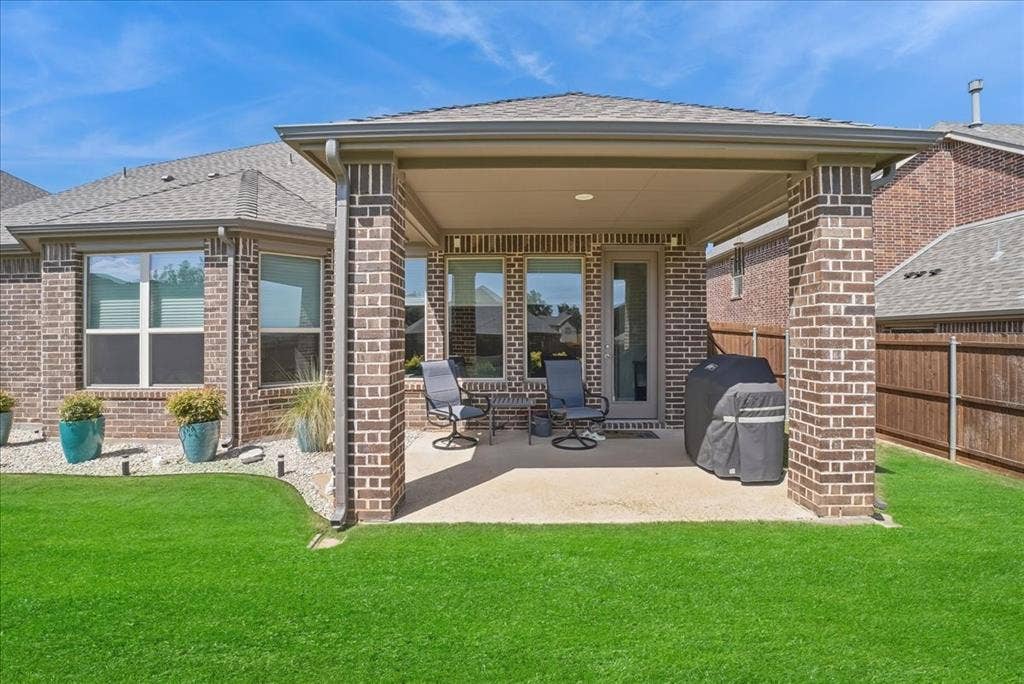 2206 Wellington Lane, Corinth, TX 76210 Covered back patio overlooking a beautifully maintained backyard, perfect for outdoor entertaining.