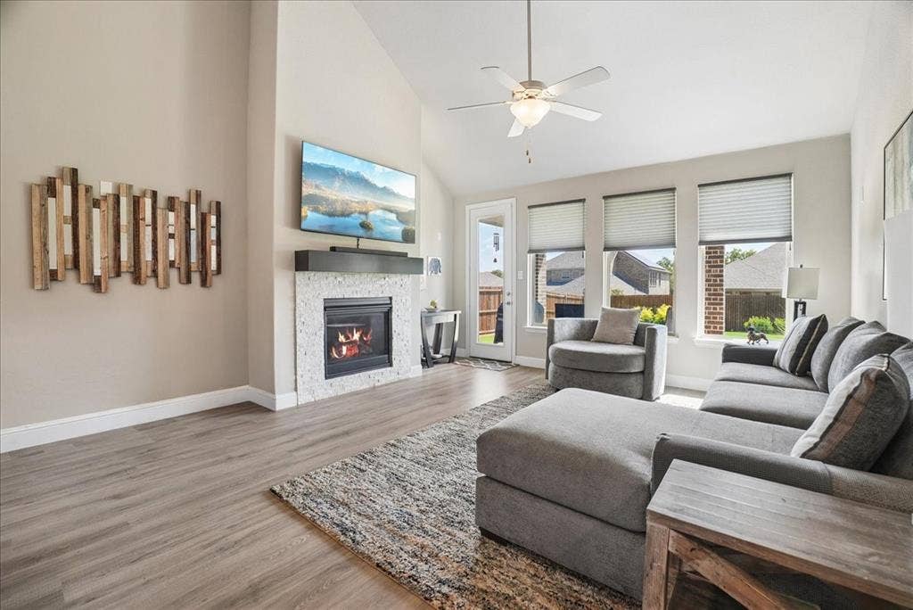 2206 Wellington Lane, Corinth, TX 76210 Bright, spacious living room with vaulted ceilings, fireplace and abundant natural light.