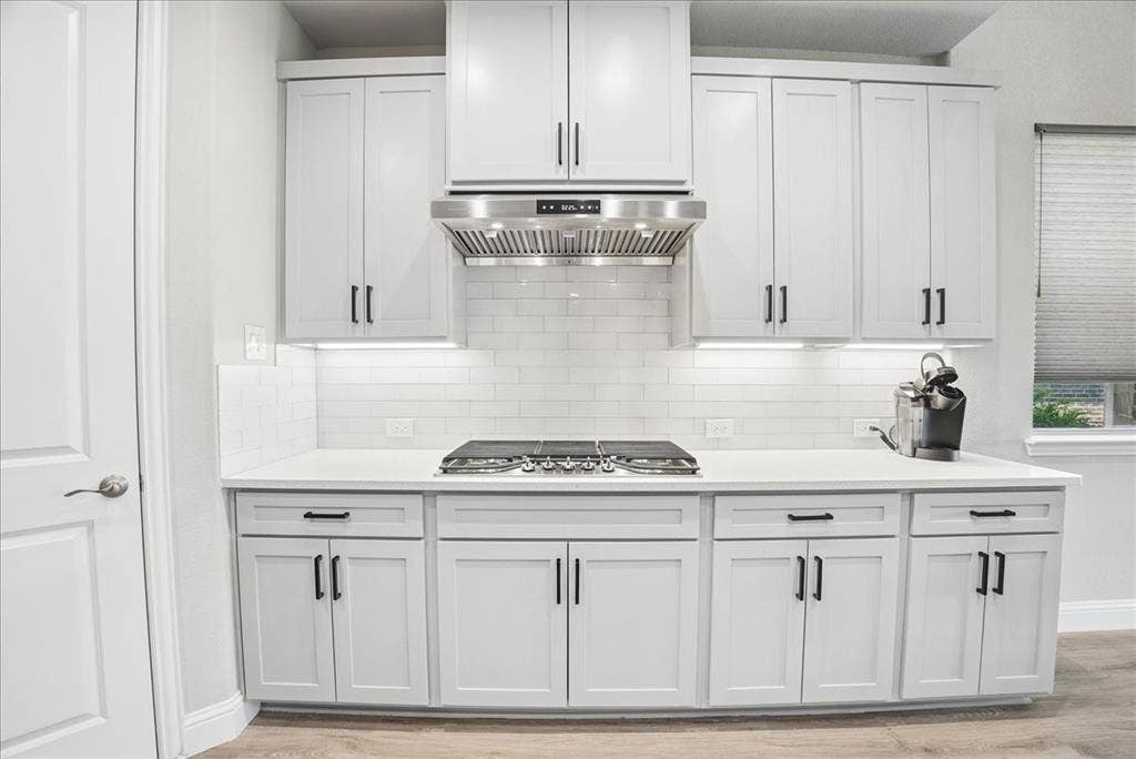 2206 Wellington Lane, Corinth, TX 76210 Upgraded vent hood, under-cabinet lighting, quartz countertops and stylish backsplash complete this beautiful kitchen.