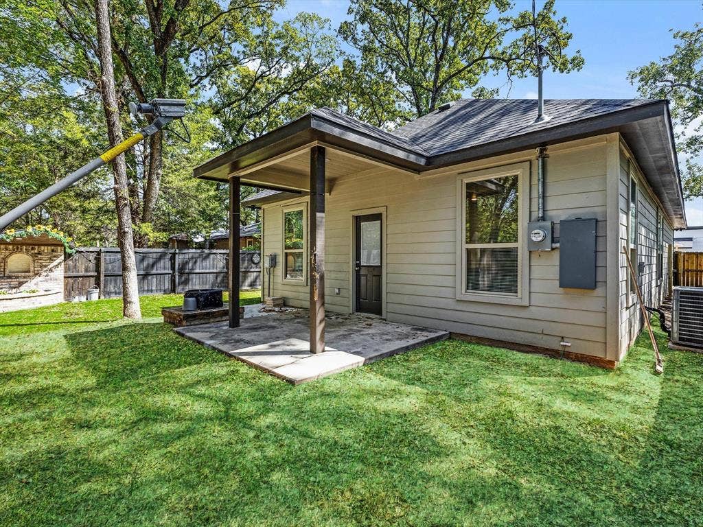 82 Indian Harbor Drive, Mabank, TX 75156 Rear exterior featuring a covered patio, neutral-toned siding, dark trim, and a shingled roof