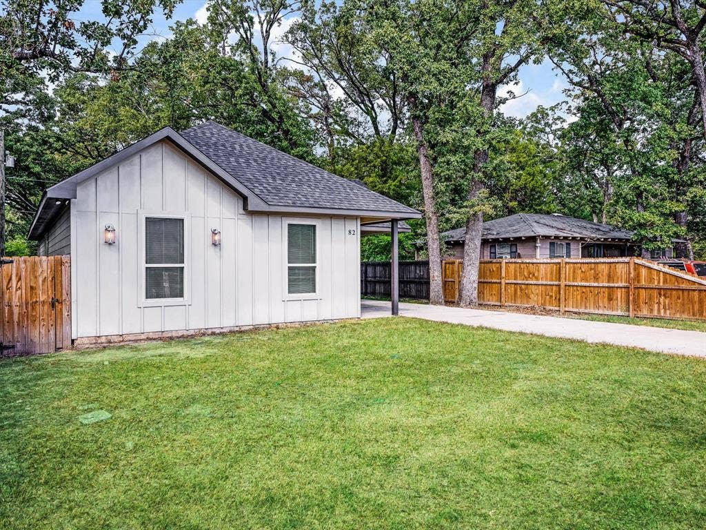 82 Indian Harbor Drive, Mabank, TX 75156 White board-and-batten siding with dual outdoor sconces