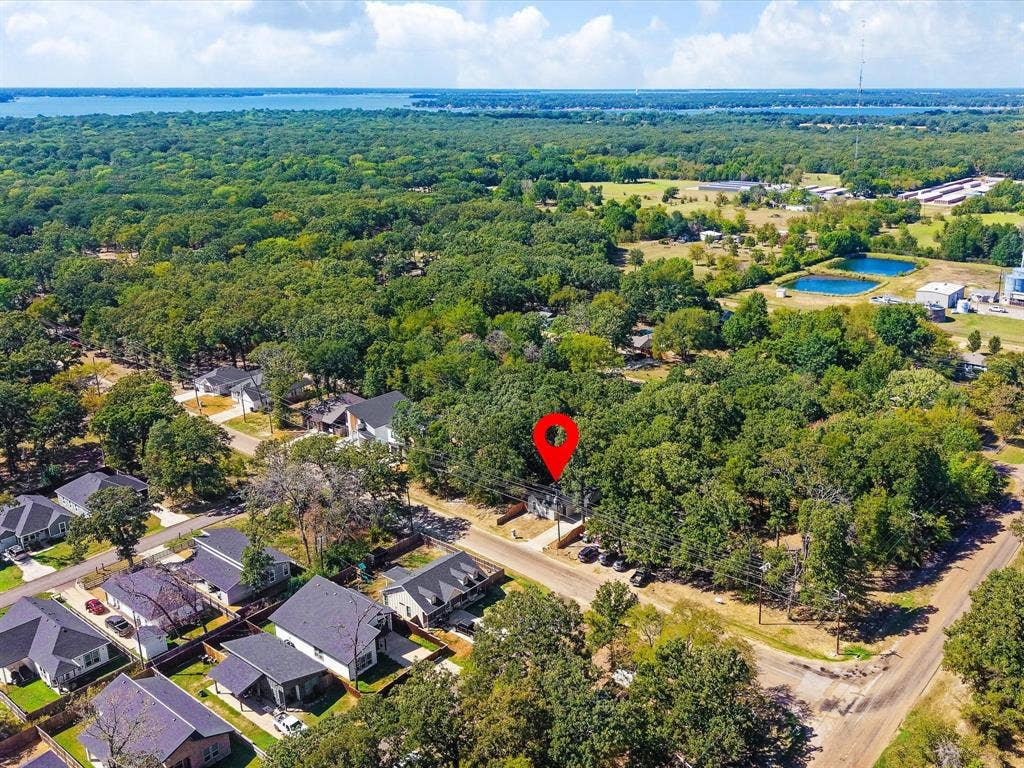 82 Indian Harbor Drive, Mabank, TX 75156 Residential property situated among mature trees, with paved roadways and neighboring homes