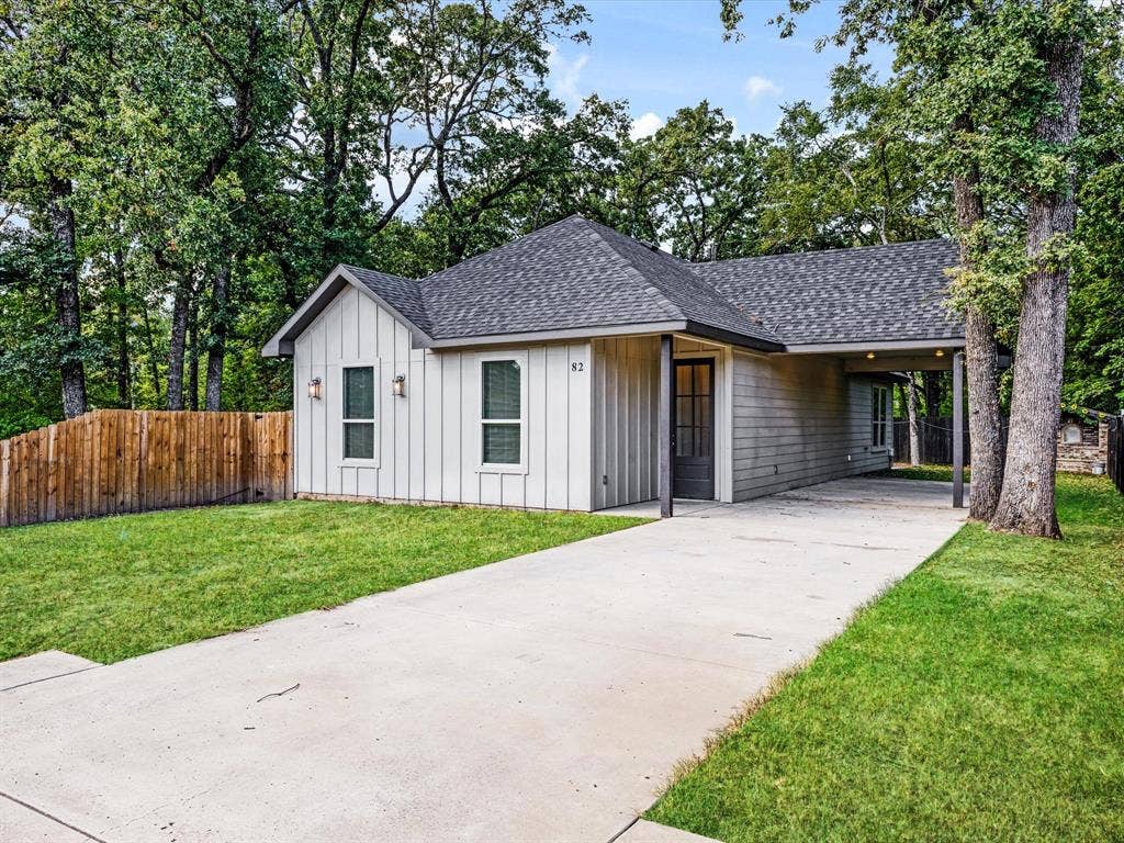 82 Indian Harbor Drive, Mabank, TX 75156 Modern farmhouse-style exterior with vertical siding, dark gray roof, and attached carport