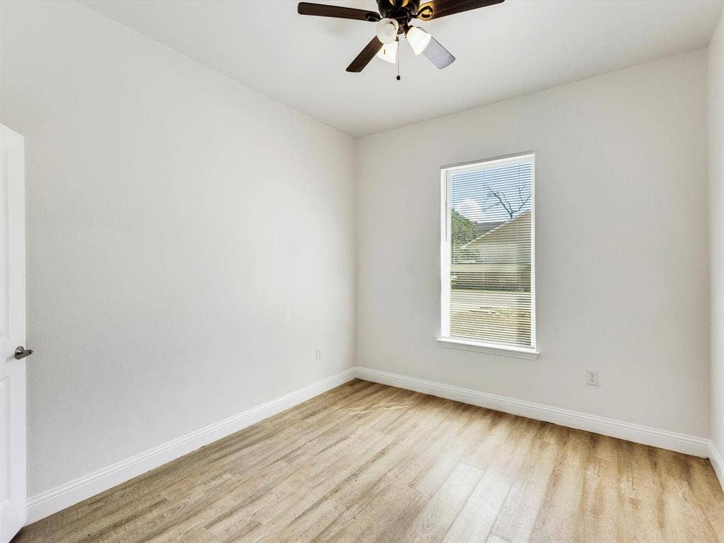 82 Indian Harbor Drive, Mabank, TX 75156 Wood-finish flooring with white baseboards, single window with blinds, and ceiling fan with integrated lighting