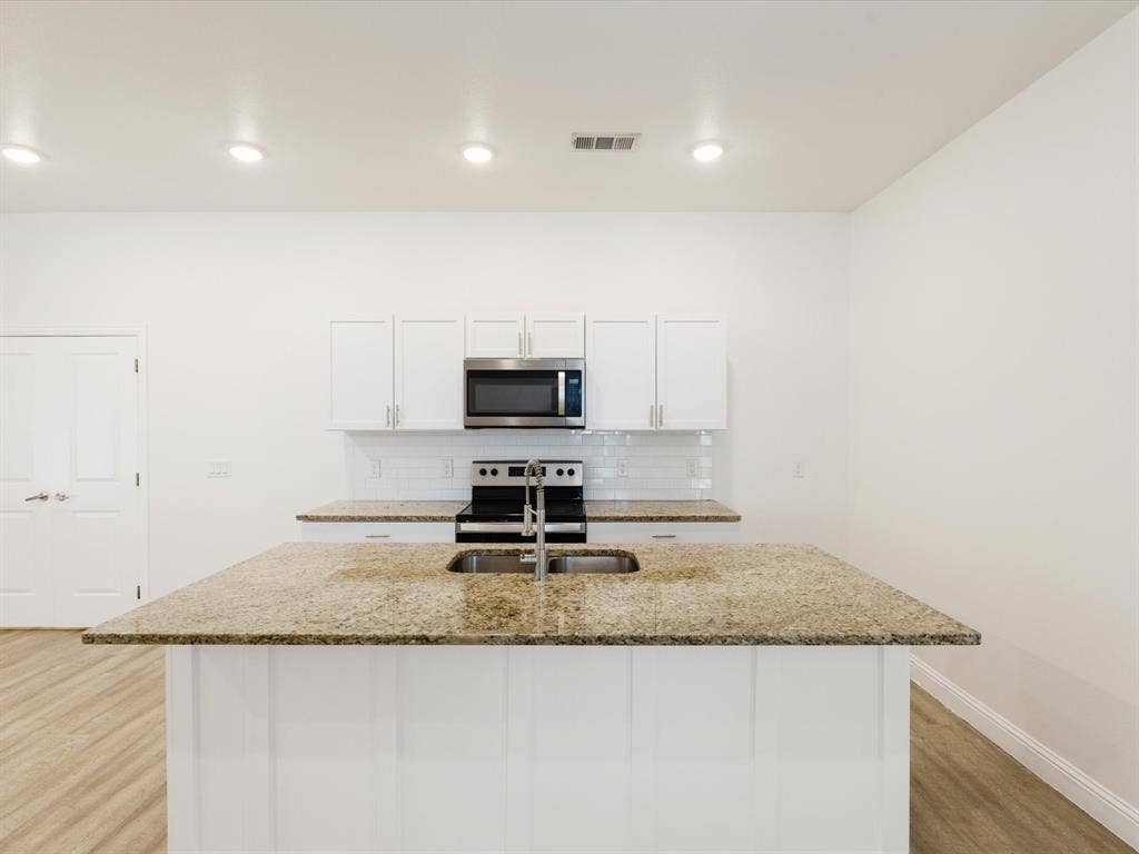 82 Indian Harbor Drive, Mabank, TX 75156 Kitchen featuring white cabinetry, granite countertops, stainless steel appliances, a tile backsplash, and recessed lighting