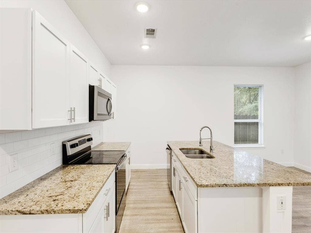 82 Indian Harbor Drive, Mabank, TX 75156 Modern kitchen featuring white cabinetry, granite countertops, an undermount double-basin sink, and recessed lighting