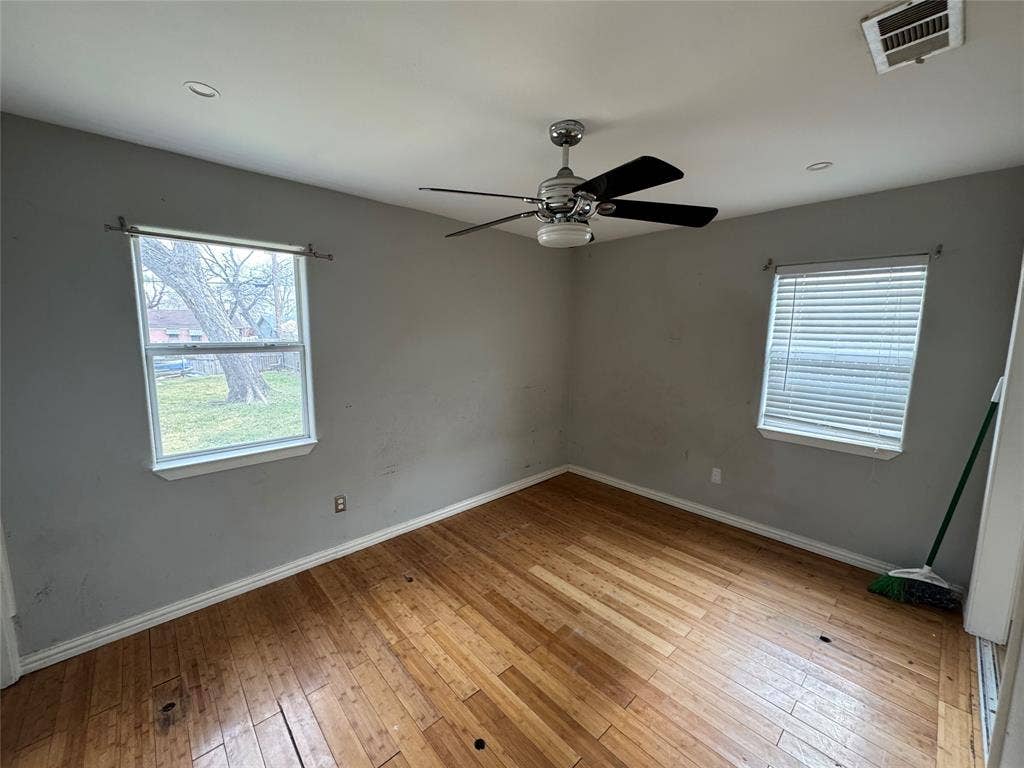 Wood-finish flooring, ceiling fan with integrated lighting, recessed ceiling lighting, and multiple windows